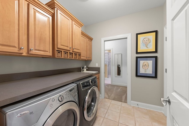 clothes washing area with washing machine and clothes dryer, cabinet space, baseboards, light tile patterned floors, and light colored carpet