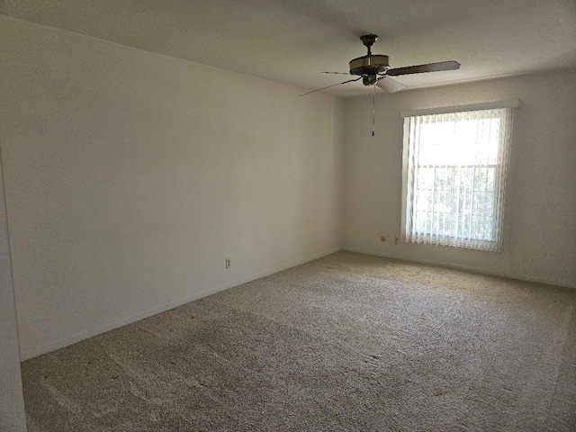 carpeted empty room featuring a ceiling fan