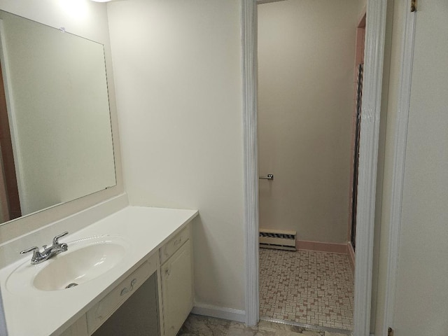 bathroom featuring a baseboard heating unit, vanity, and baseboards