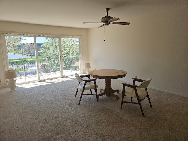 dining space featuring a ceiling fan, carpet flooring, and baseboards