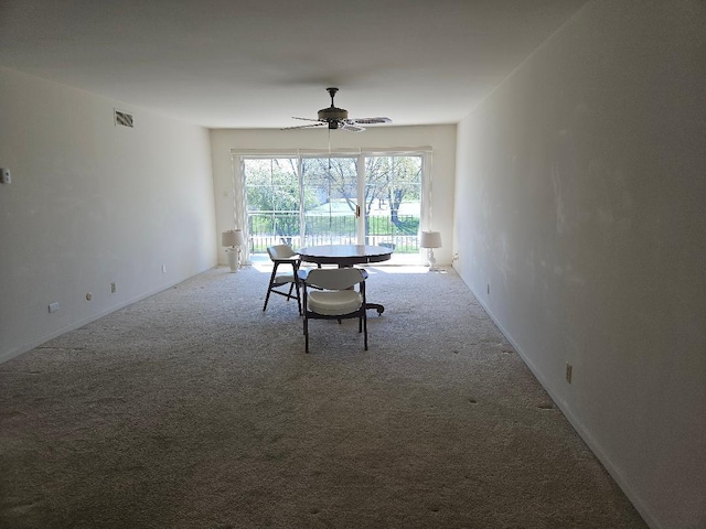 carpeted dining room with visible vents and ceiling fan