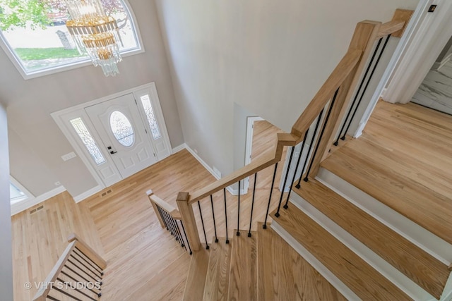 1188 Parkview Ct, Carol Stream, IL 60188 - entryway featuring stairway, wood finished floors, a towering ceiling, and a notable chandelier