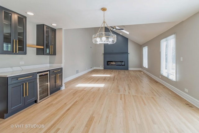 1188 Parkview Ct, Carol Stream, IL 60188 - interior space featuring a fireplace, a chandelier, beverage cooler, baseboards, and light wood-style floors