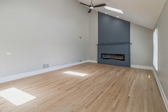 1188 Parkview Ct, Carol Stream, IL 60188 - unfurnished living room with a ceiling fan, baseboards, lofted ceiling with skylight, visible vents, and light wood-type flooring