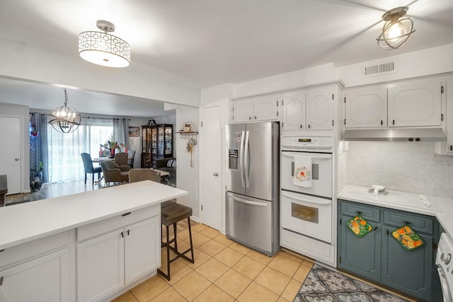 5328 W Windsor Ave Unit 1H, Chicago, IL 60630 - kitchen featuring white double oven, visible vents, light countertops, under cabinet range hood, and stainless steel refrigerator with ice dispenser