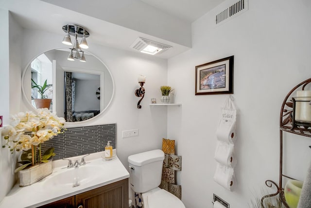 5328 W Windsor Ave Unit 1H, Chicago, IL 60630 - bathroom featuring toilet, visible vents, vanity, and tasteful backsplash