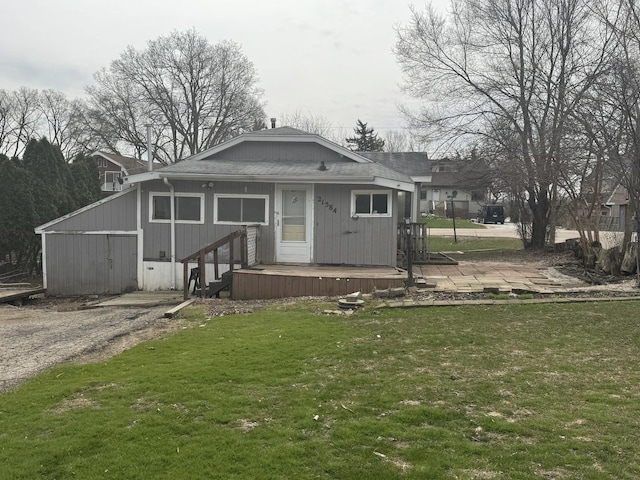 rear view of property with a yard and a shingled roof