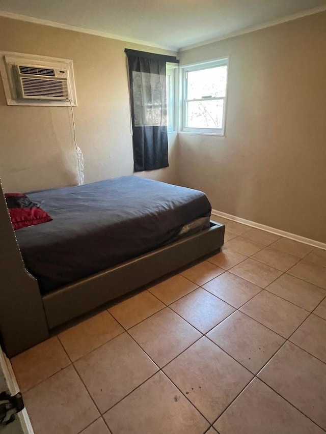 tiled bedroom featuring a wall mounted AC, ornamental molding, and baseboards