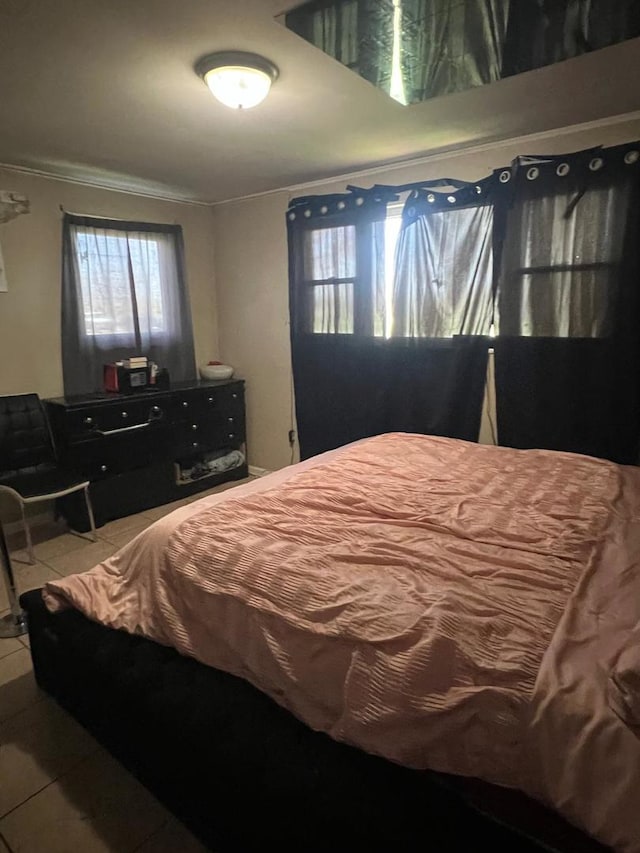bedroom with crown molding and tile patterned flooring