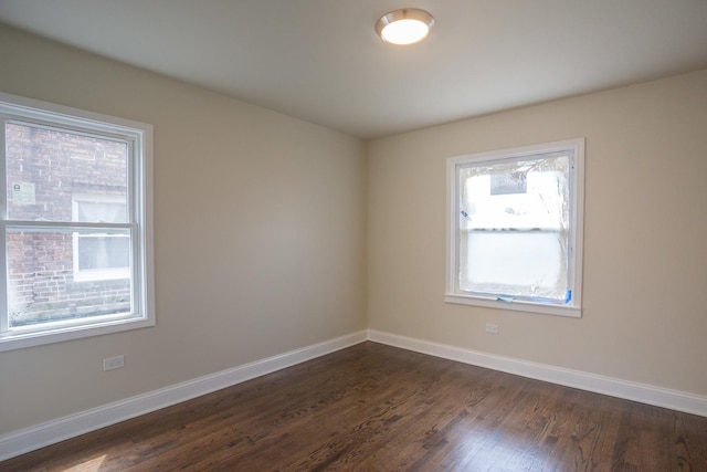 empty room with dark wood-style floors and baseboards