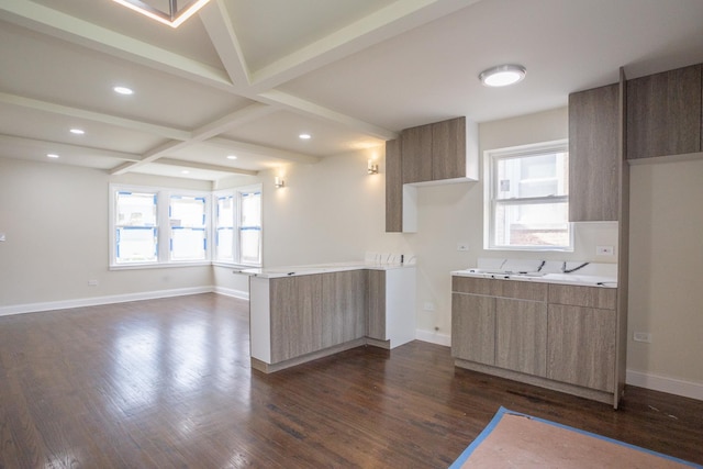 interior space featuring beamed ceiling, modern cabinets, light countertops, dark wood-type flooring, and baseboards