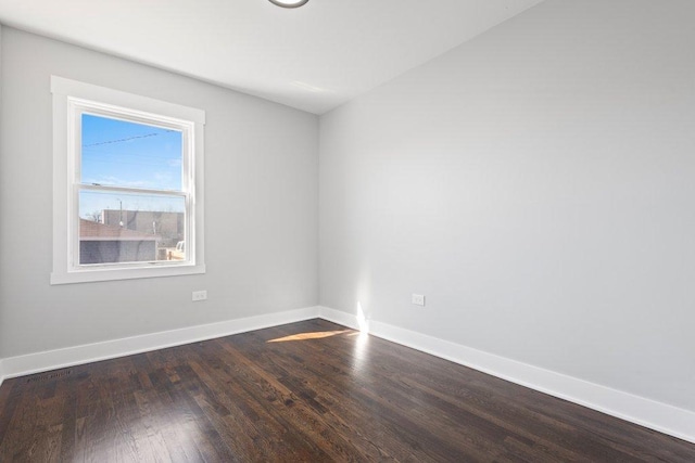 unfurnished room featuring dark wood-style floors and baseboards