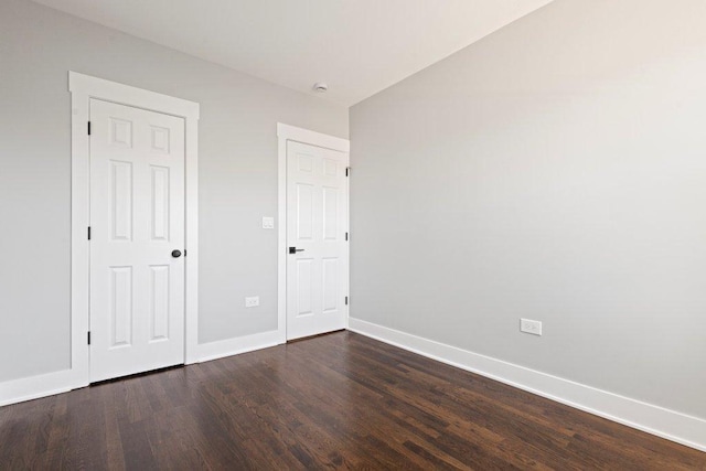 unfurnished bedroom with dark wood-style floors and baseboards