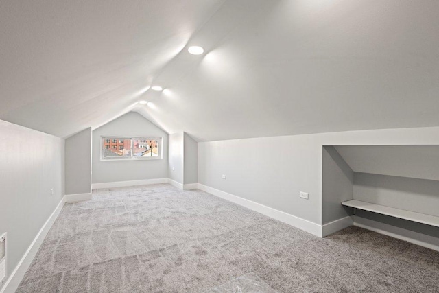 bonus room with baseboards, lofted ceiling, and carpet flooring