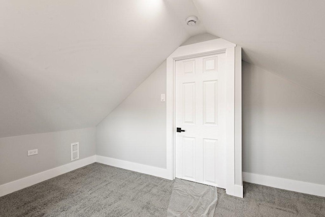 additional living space with baseboards, visible vents, carpet floors, and lofted ceiling