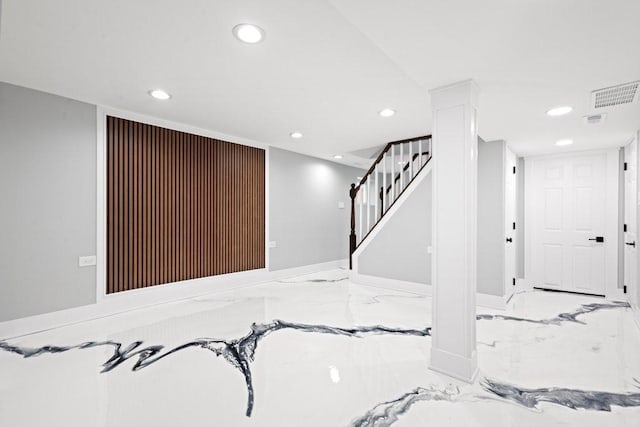 finished basement featuring visible vents, baseboards, recessed lighting, marble finish floor, and stairs