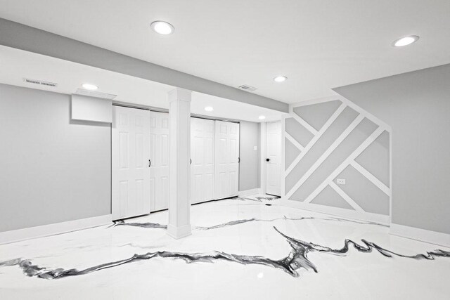 finished below grade area featuring visible vents, recessed lighting, marble finish floor, and baseboards