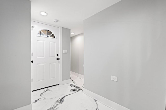 foyer with recessed lighting, marble finish floor, and baseboards