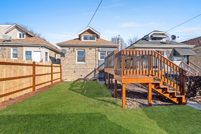 back of property with stairway, fence, a wooden deck, and a lawn