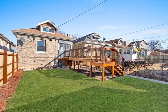 back of house featuring a deck, stairway, brick siding, and a fenced backyard