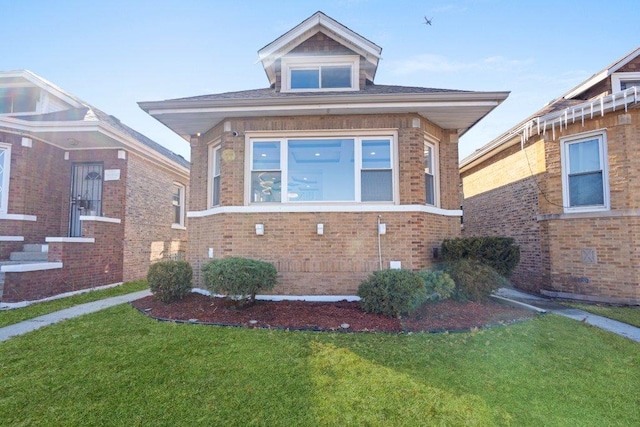 bungalow with a front yard and brick siding