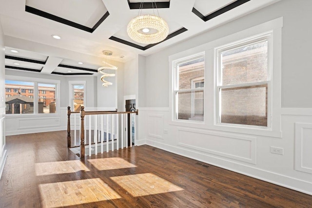 interior space featuring an upstairs landing, dark wood-type flooring, a decorative wall, and coffered ceiling