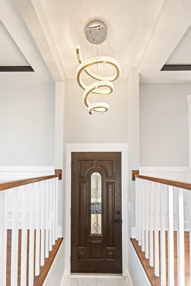 foyer featuring baseboards and a notable chandelier
