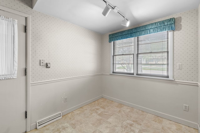 spare room featuring rail lighting, visible vents, wallpapered walls, and baseboards