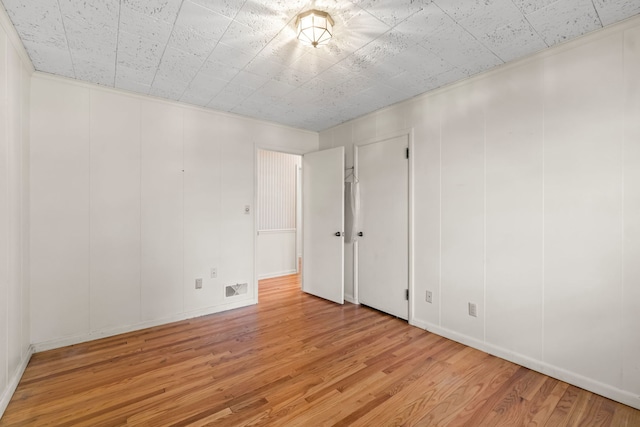 unfurnished room featuring visible vents and wood finished floors