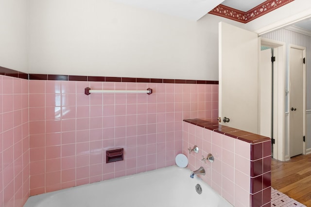 bathroom with wood finished floors and a washtub