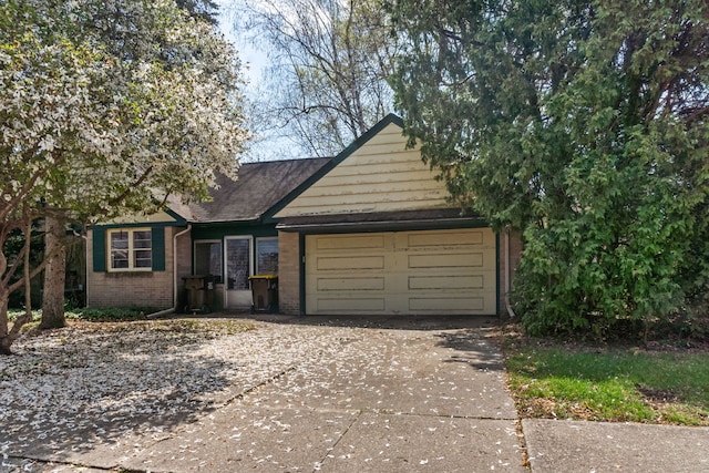 view of front of home with driveway, brick siding, and a garage