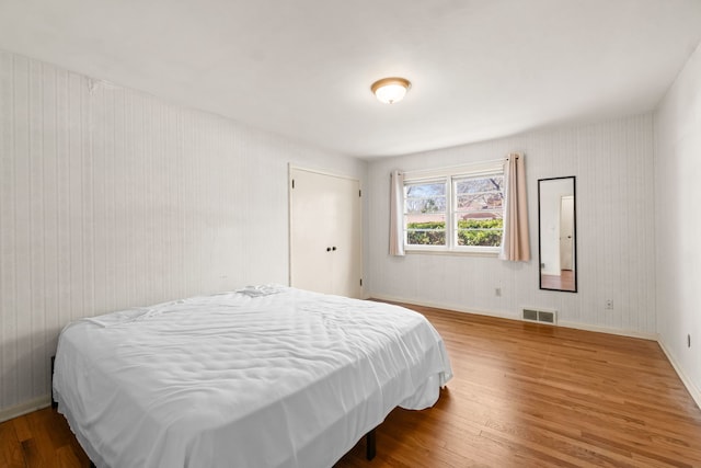 bedroom featuring wood finished floors and visible vents