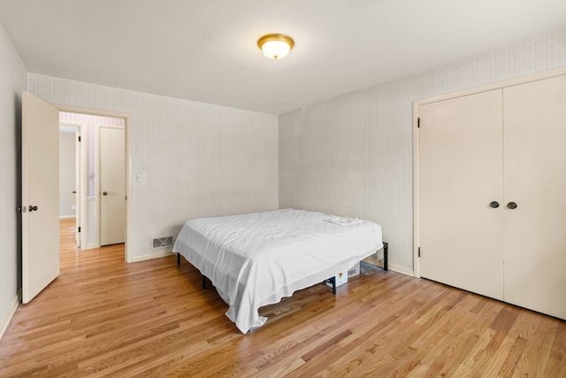 bedroom featuring visible vents, a closet, light wood-style flooring, and baseboards