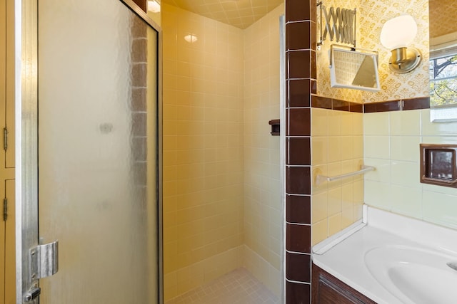 full bathroom with tile walls, a stall shower, and vanity