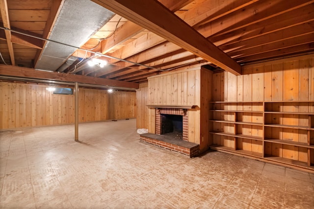 finished below grade area with tile patterned floors, wood walls, and a brick fireplace