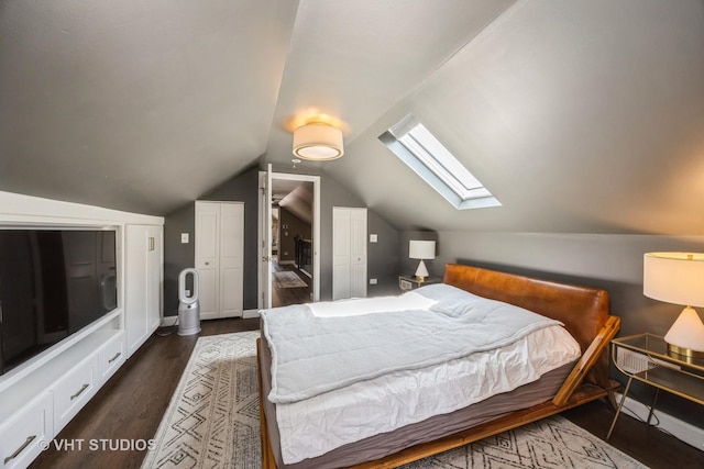 bedroom featuring vaulted ceiling with skylight, baseboards, and dark wood-style flooring