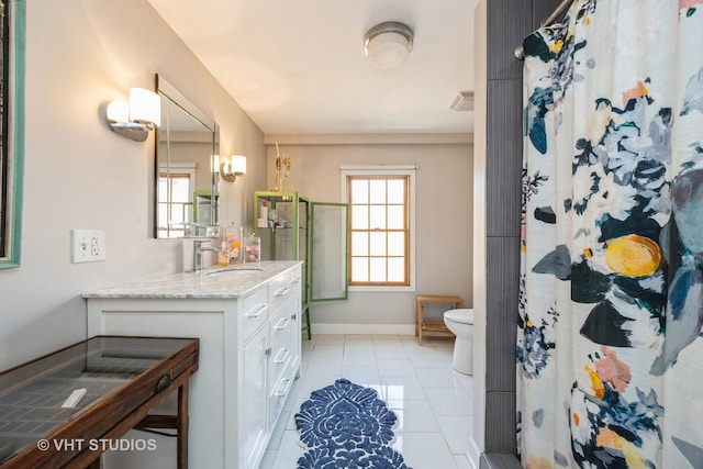 bathroom featuring toilet, plenty of natural light, tile patterned flooring, and vanity