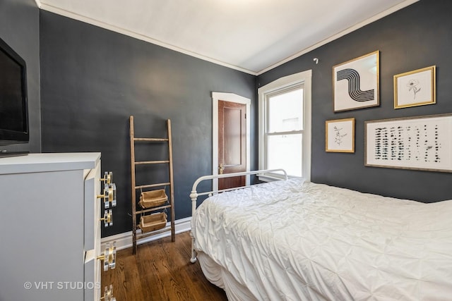 bedroom featuring baseboards, ornamental molding, and wood finished floors