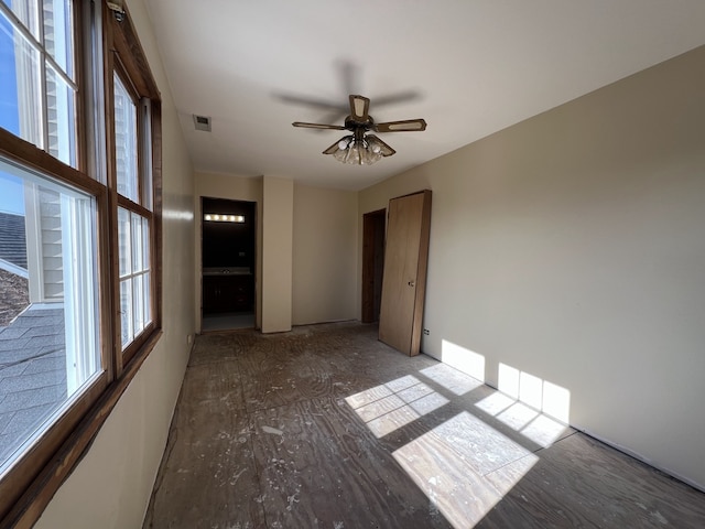 spare room featuring a wealth of natural light, ceiling fan, and visible vents