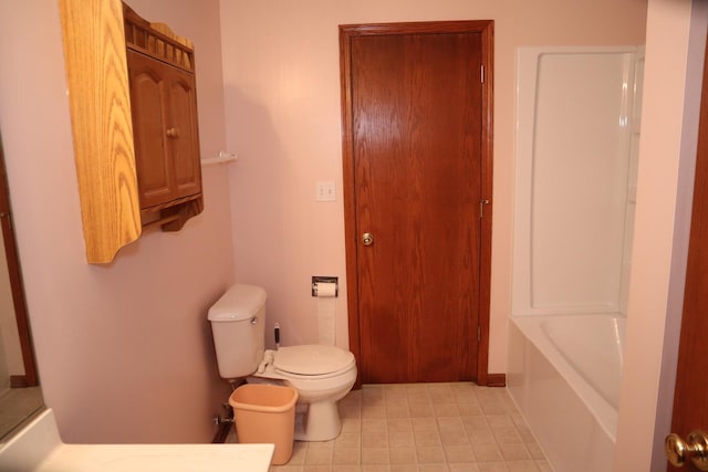 bathroom featuring tile patterned floors, a bathtub, and toilet