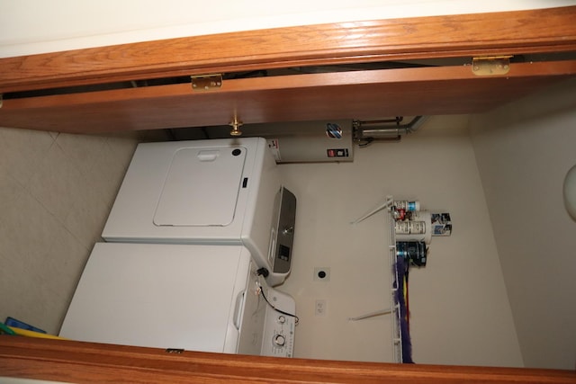 laundry area featuring stacked washer / drying machine and laundry area
