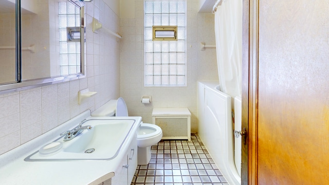 bathroom with tile walls, toilet, vanity, tile patterned floors, and shower / bath combo