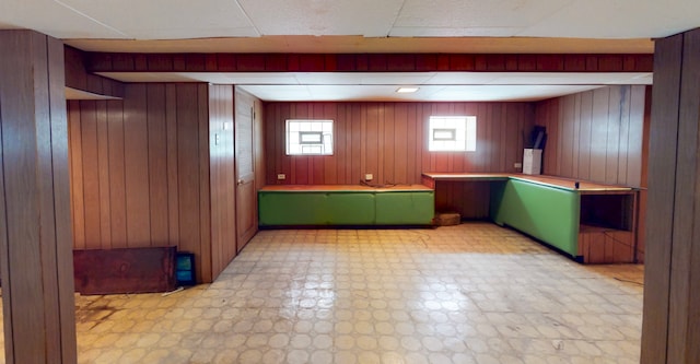 bar featuring light flooring and wooden walls