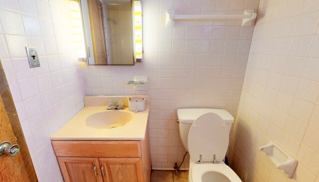 bathroom with tile walls, vanity, and toilet