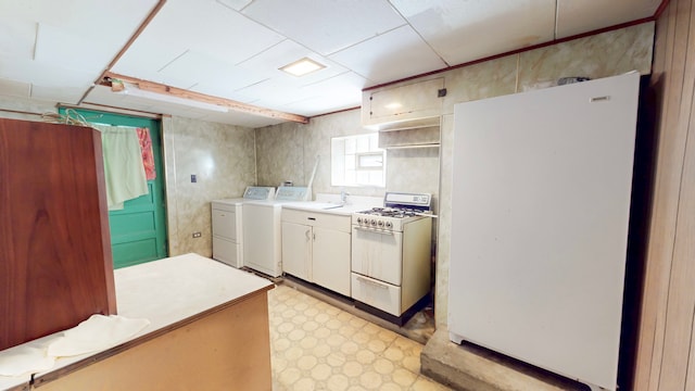 kitchen with white appliances, light countertops, washing machine and clothes dryer, light floors, and white cabinetry