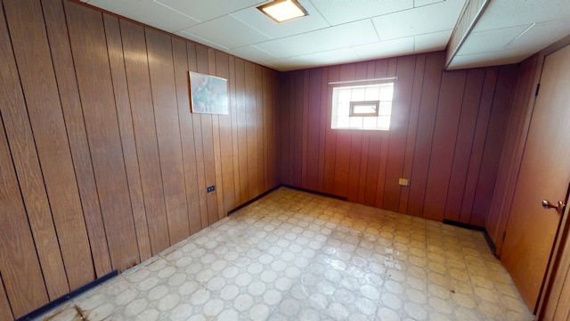 empty room with light floors and wooden walls