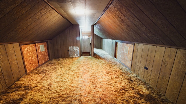 bonus room featuring wood walls, carpet floors, and lofted ceiling