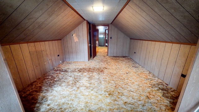 bonus room featuring wood walls, carpet, and vaulted ceiling