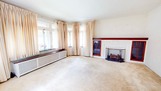 unfurnished living room featuring radiator heating unit, carpet flooring, a fireplace, and crown molding