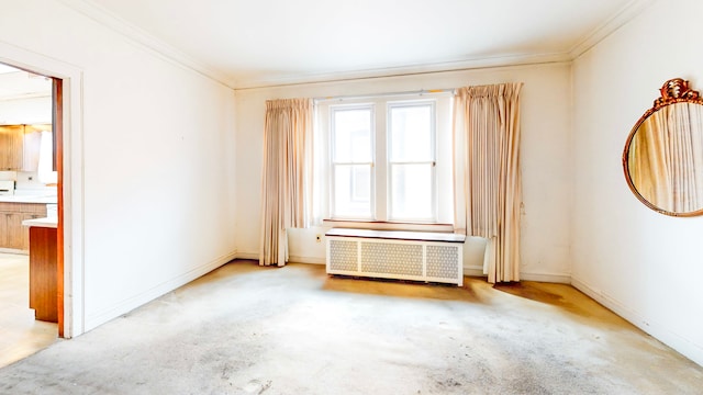 spare room with radiator, crown molding, baseboards, and light carpet